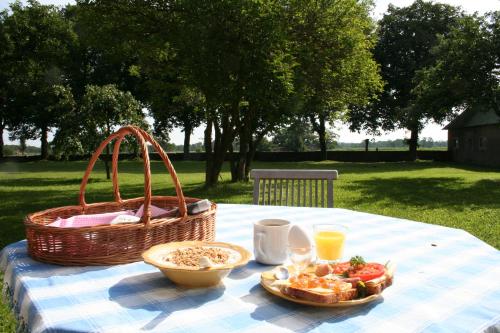 una mesa de picnic con una cesta y comida. en Greby Bed & Breakfast en Räpplinge