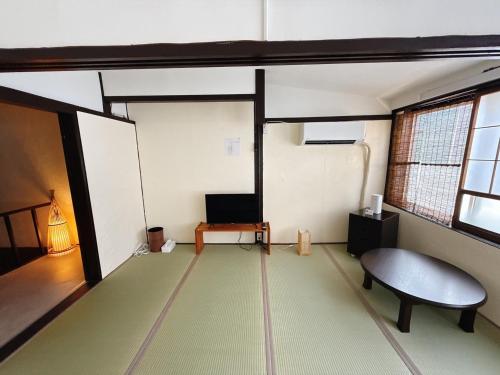 a room with a table and a bench in a room at つむぎの宿いちTsumugi's inn Ichi in Joetsu