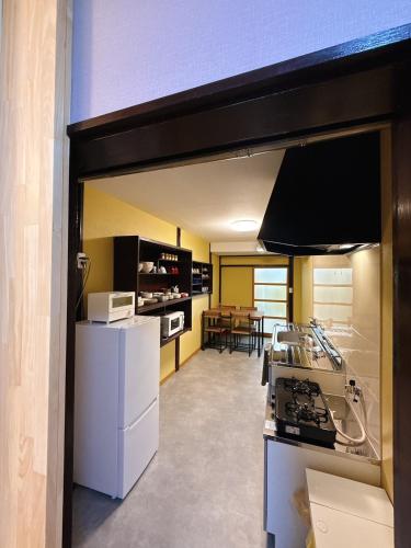 a kitchen with white appliances and a dining room at つむぎの宿いちTsumugi's inn Ichi in Joetsu