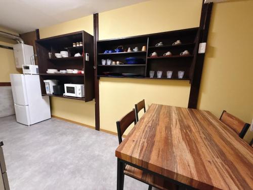 a dining room with a table and a refrigerator at つむぎの宿いちTsumugi's inn Ichi in Joetsu
