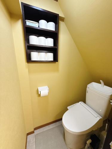 a bathroom with a toilet and a shelf with towels at つむぎの宿いちTsumugi's inn Ichi in Joetsu