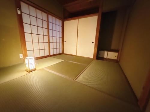 an empty room with white doors and a small stool at つむぎの宿いちTsumugi's inn Ichi in Joetsu