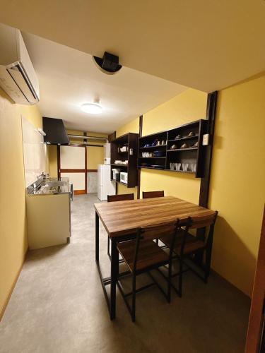 a kitchen with a wooden table and chairs in a room at つむぎの宿いちTsumugi's inn Ichi in Joetsu