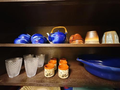 a shelf with different colored bowls and cups on it at つむぎの宿いちTsumugi's inn Ichi in Joetsu