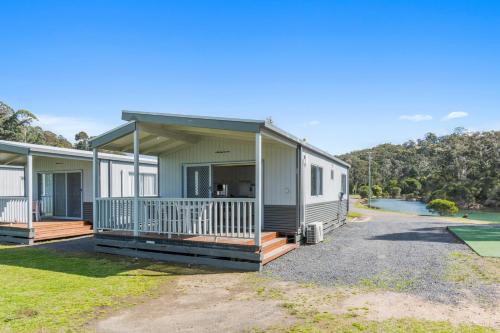 a manufactured home with a porch and a house at Ingenia Holidays Eden Beachfront in Eden