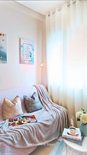a bedroom with a bed with a window and a table at The Lumiére Stays Sophisticated Escape Mallside Charm in Trece Martires