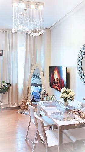 a white dining room with a white table and chairs at The Lumiére Stays Sophisticated Escape Mallside Charm in Trece Martires