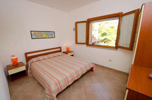 a small bedroom with a bed and a window at AIR Borgo della Torre in Isola Rossa