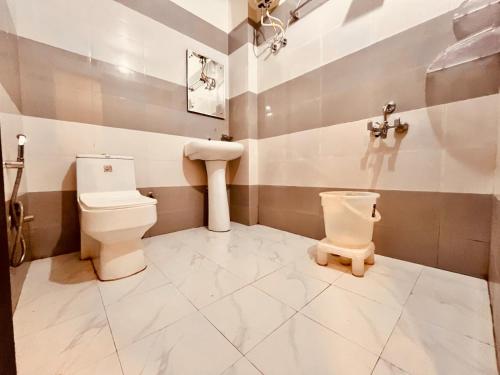 a bathroom with a toilet and a sink at Hotel The Pacific, Haridwar in Haridwār