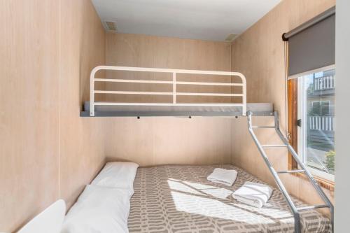 a bunk bed in a small room with a window at Ingenia Holidays Eden Beachfront in Eden