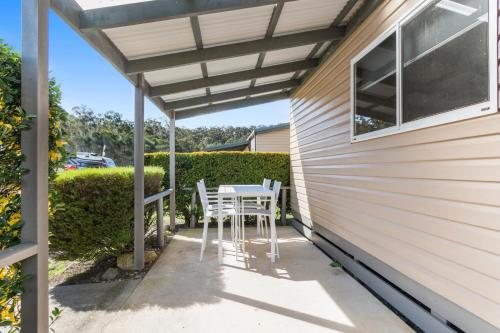 a patio with a table and chairs under a pergola at Ingenia Holidays Eden Beachfront in Eden