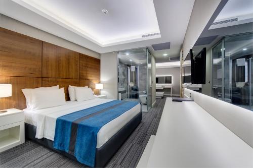 Cette chambre comprend un lit et une télévision. dans l'établissement The Menord Hotel, à Mersin