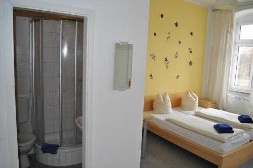 a room with two beds and a shower and a bathroom at A bed Privatzimmer Dresden - Nichtraucherpension in Dresden