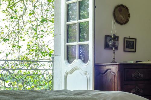 a bedroom with a bed and a window and a dresser at Château d’Orion in Orion