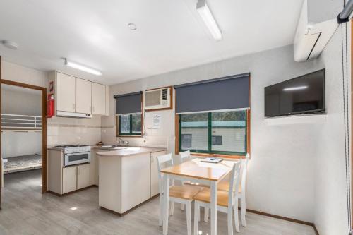a kitchen with a table and chairs in a room at Ingenia Holidays Eden Beachfront in Eden