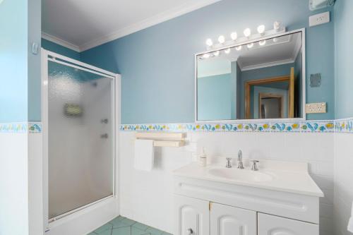 a bathroom with a sink and a shower with a mirror at Ingenia Holidays Eden Beachfront in Eden