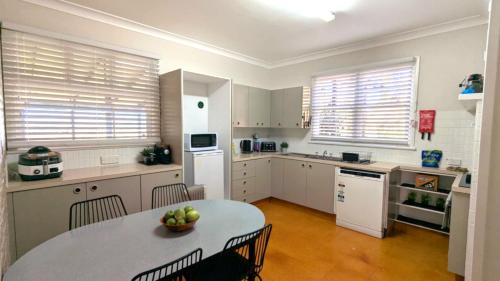 a kitchen with a table with a bowl of fruit on it at Jenolan Street Chalet in Oberon