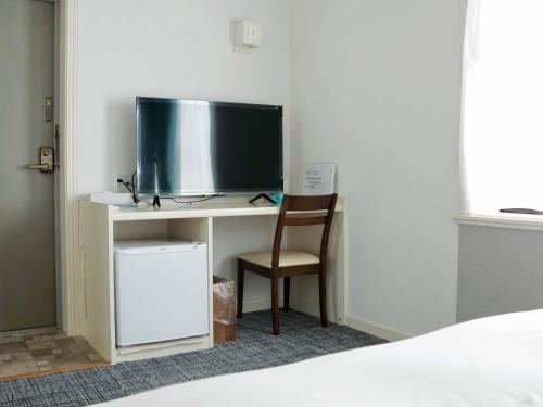 a bedroom with a desk with a tv and a chair at Hananoie華之家 in Tokyo