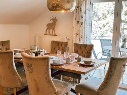 a dining room with a wooden table and chairs at Bachgeflüster-Suite in Bad Koetzting