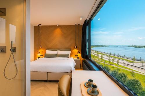 a bedroom with a bed and a large window at Kaai11 - Riverview Lofts & Suites in Antwerp