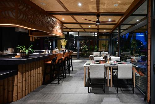 a restaurant with tables and chairs and a bar at Big Sun Residences By iRETREAT in Ko Yao Noi