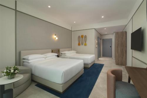 a hotel room with two beds and a television at Hyatt Centric Santo Domingo in Santo Domingo