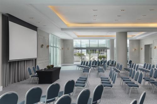 a conference room with chairs and a podium and a screen at Hyatt Centric Santo Domingo in Santo Domingo