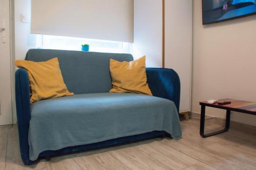 a blue couch with two yellow pillows in a room at Private Secluded Studio in Sesvete
