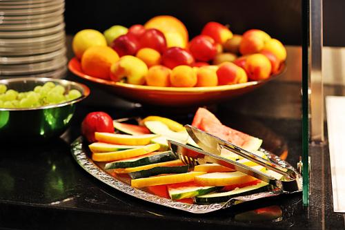 una bandeja de fruta en una mesa con un tazón de manzanas en Green Deer Bavarian Hotel, en Langenbruck