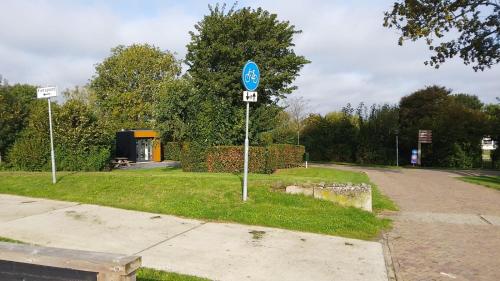 a blue street sign on the side of a road at Chalet Meerwijck mit Terrasse am Wasser und Meer mit Schwimmbad in Kropswolde