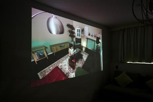 a painting of a woman sitting in a living room at THE ROOT2 HOTEL in Kyoto