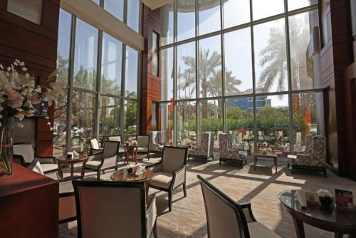 a large room with chairs and tables and windows at Qaser Al Hamra Hotel in Riyadh