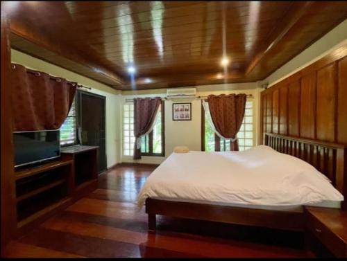 een slaapkamer met een bed en een flatscreen-tv bij Harmony Home in Hang Dong