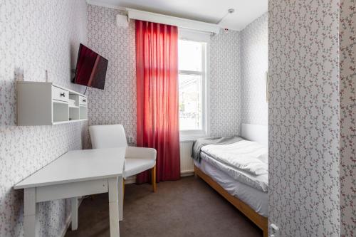 a small room with a bed and a window at Hotel Ranten in Falköping