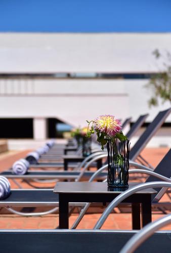 a row of tables and chairs with a vase of flowers at Pousada Mosteiro do Crato in Crato