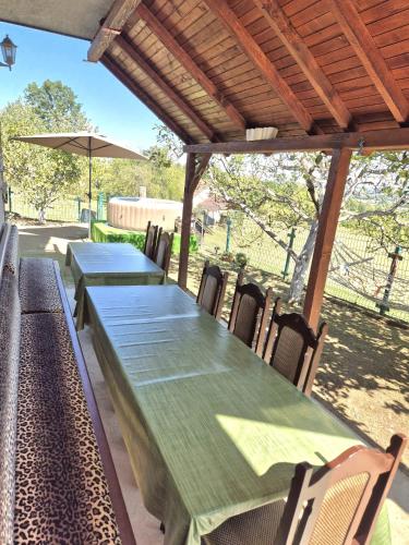 a green table and chairs under a wooden roof at Zeleni horizont 