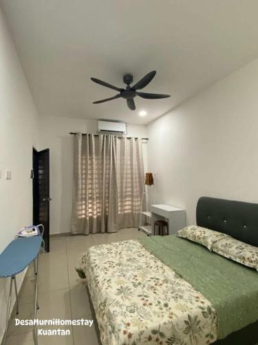a bedroom with a bed and a ceiling fan at Desa Murni Homestay in Kuantan