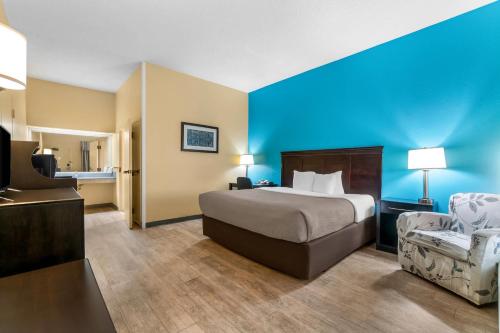 a hotel room with a bed and a chair at Quality Inn Union City US 51 in Union City