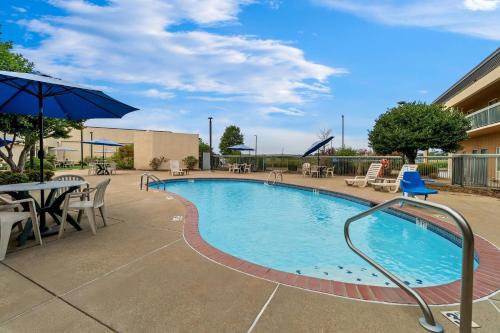 a swimming pool with a table and chairs and an umbrella at Quality Inn Union City US 51 in Union City