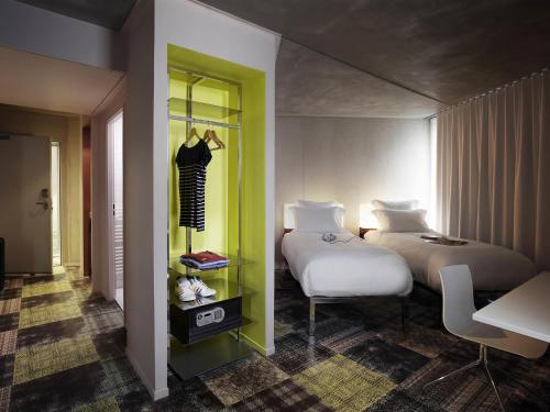 a bedroom with a bed and a room with a table at Mama Shelter Marseille in Marseille