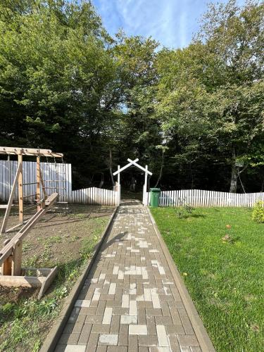 a brick walkway in a yard with a white fence at AFORREST Family Resort in Qusar