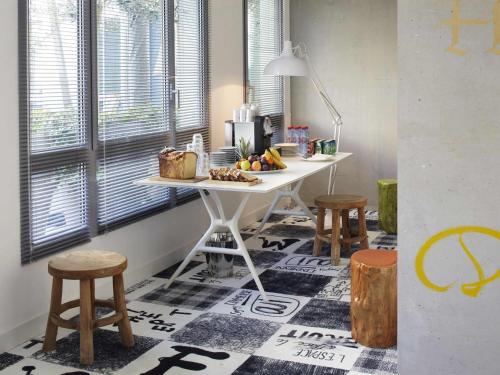 a kitchen with a table and two stools at Mama Shelter Marseille in Marseille