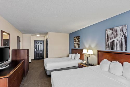 a hotel room with two beds and a flat screen tv at Rodeway Inn in Barboursville