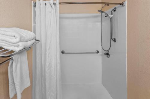 a shower door in a bathroom with white towels at Rodeway Inn in Barboursville