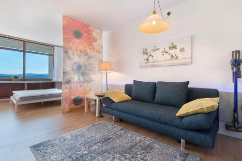 a living room with a blue couch and a table at Fewo S22 in Regen