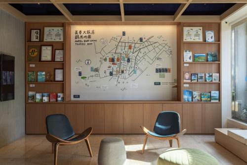 two chairs in a waiting room with a large wall at Hotel Ever Spring - Penghu in Magong