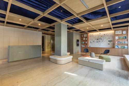 a lobby with a couch and a table and chairs at Hotel Ever Spring - Penghu in Magong