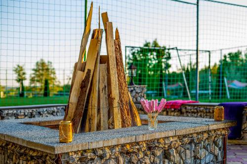 a stone table with a bunch of wooden boards at PENSIUNEA MIHAELA-Transalpina in Novaci