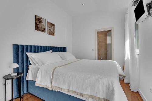 a white and blue bedroom with a large bed at Villa Svilla - Makarska Exklusiv in Drasnice