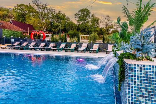 a swimming pool with chairs and a water slide at PENSIUNEA MIHAELA-Transalpina in Novaci